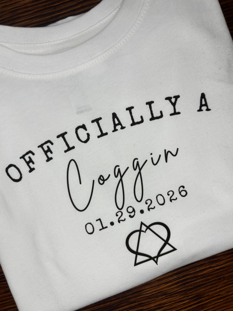White shirt with black text and design on a wooden surface