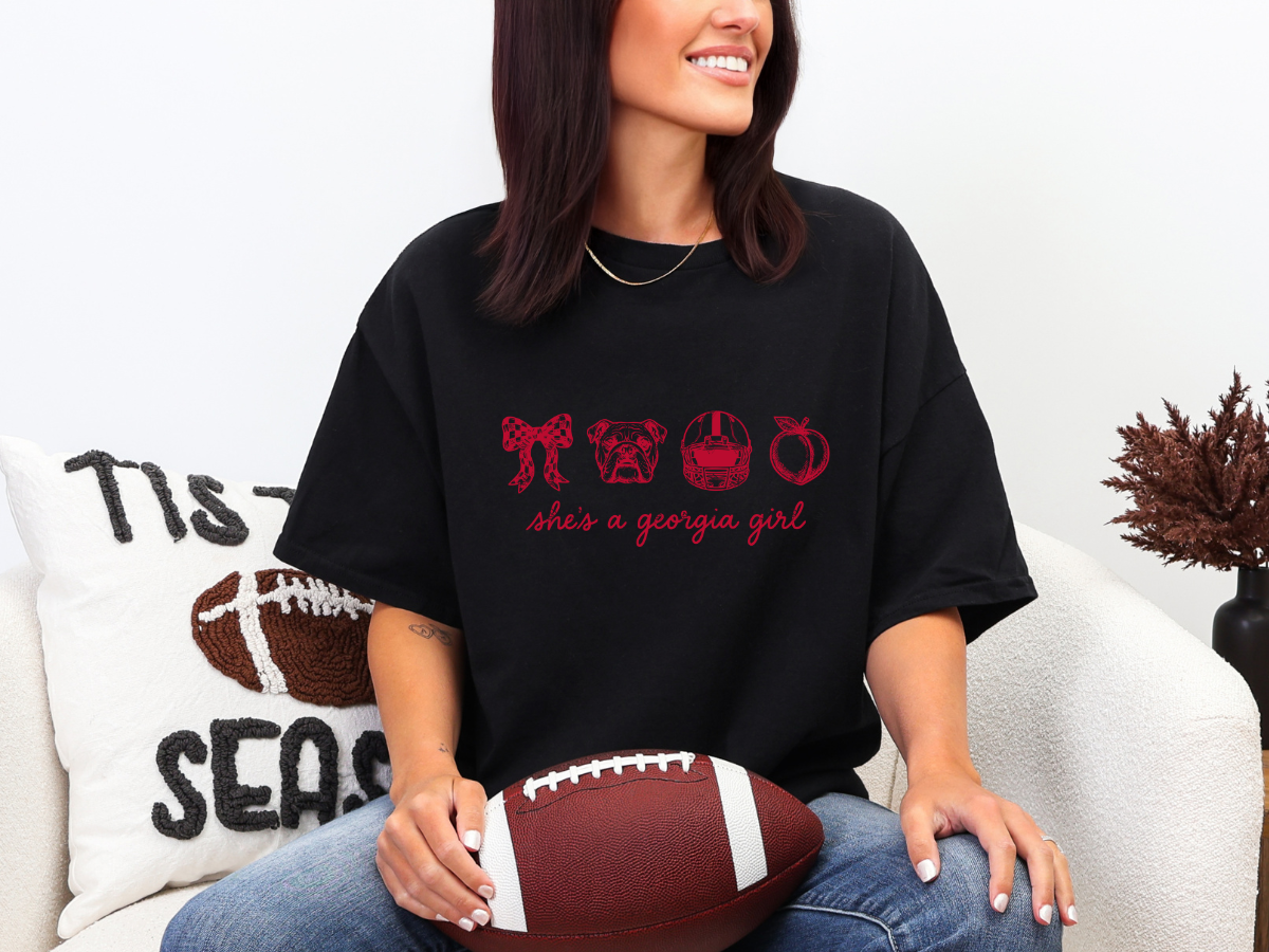 Woman wearing a black She’s a Georgia Girl football graphic tee with red design