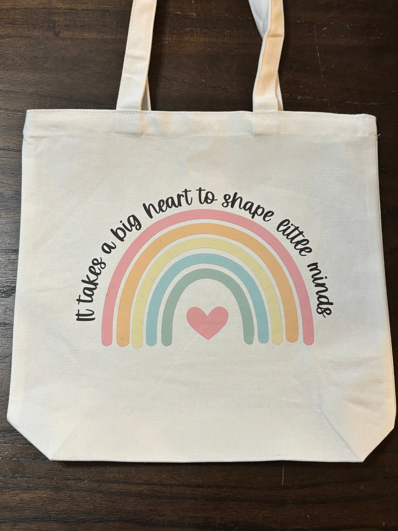 Tote bag with rainbow and text design on a wooden surface