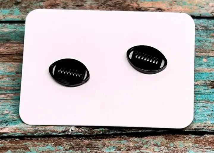 Pair of black football-shaped stud earrings with white stitching