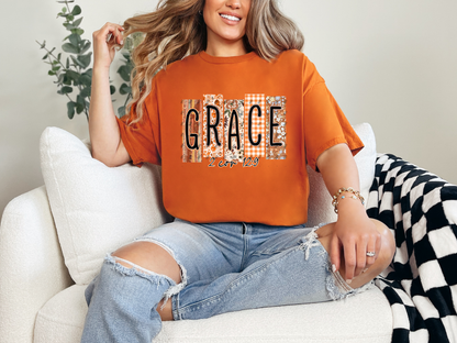 Orange Christian graphic tee with fall patterned GRACE design and 2 Corinthians 12:9 scripture