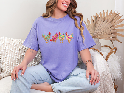 Woman wearing a purple colorful chicken graphic tee featuring four watercolor-style hens