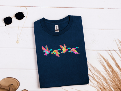 Colorful flying ducks graphic tee in navy displayed in a styled flat lay