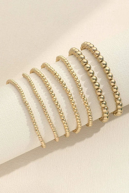 Stackable gold beaded bracelet set featuring mixed round bead sizes