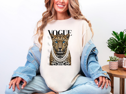 Woman wearing a Natural Leopard Vogue graphic tee featuring a fashionable leopard with blue eyes, layered pearl necklaces, and bold Vogue-inspired typography.